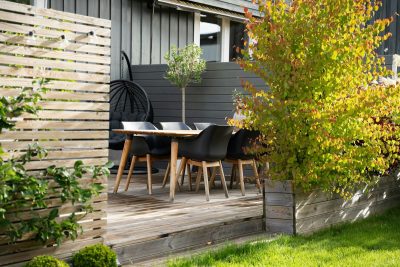 A patio with a table and chairs next to a fence