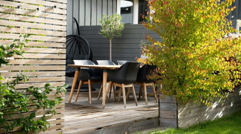 A patio with a table and chairs next to a fence