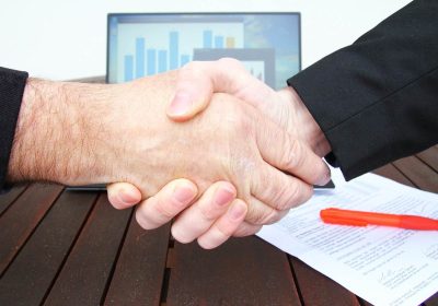Deux mains se serrant sur une table en bois